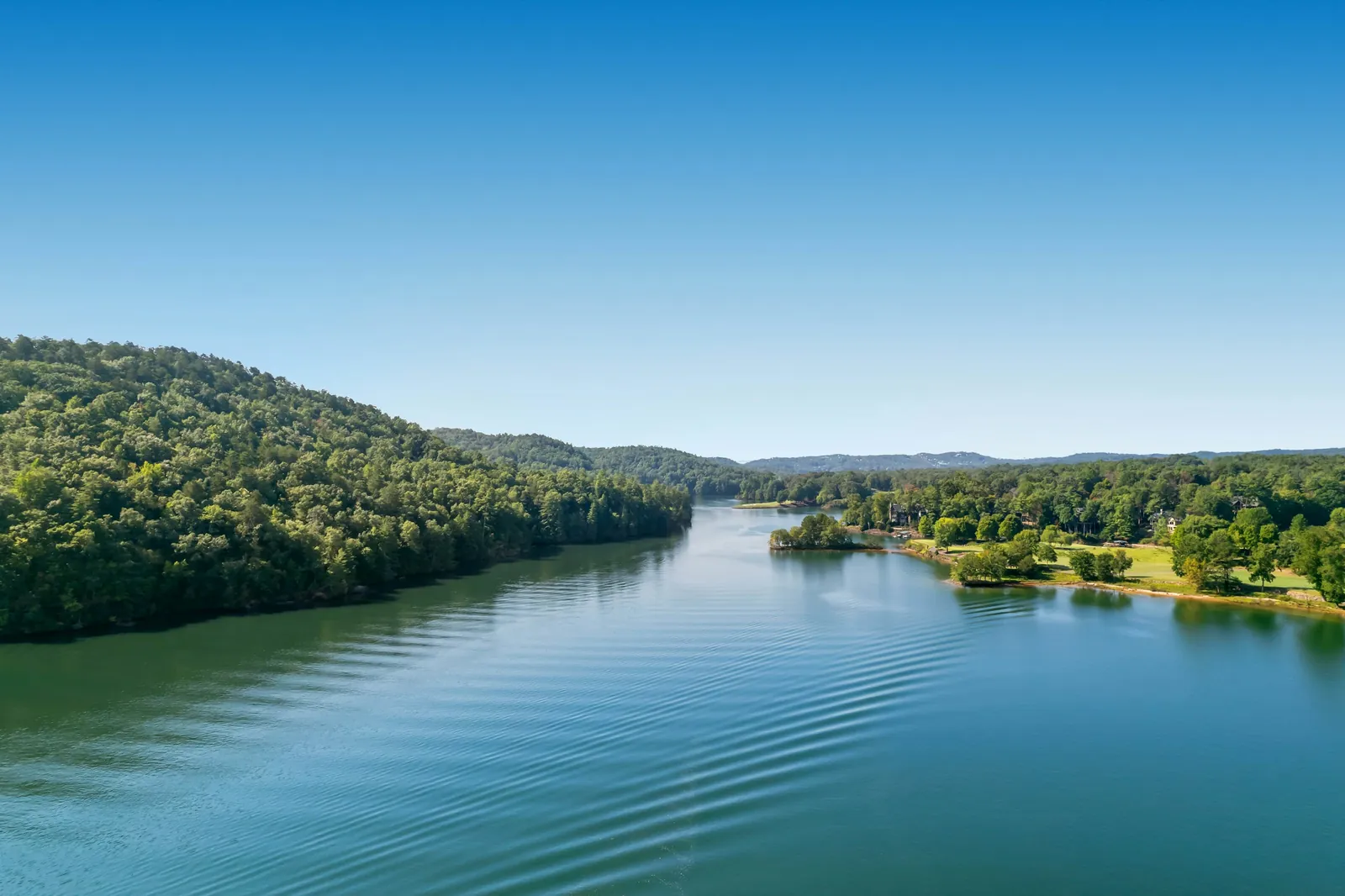 Aerial view of the blue-green water of Lake Keowee lined with wooded shoreline in Oconee County, South Carolina