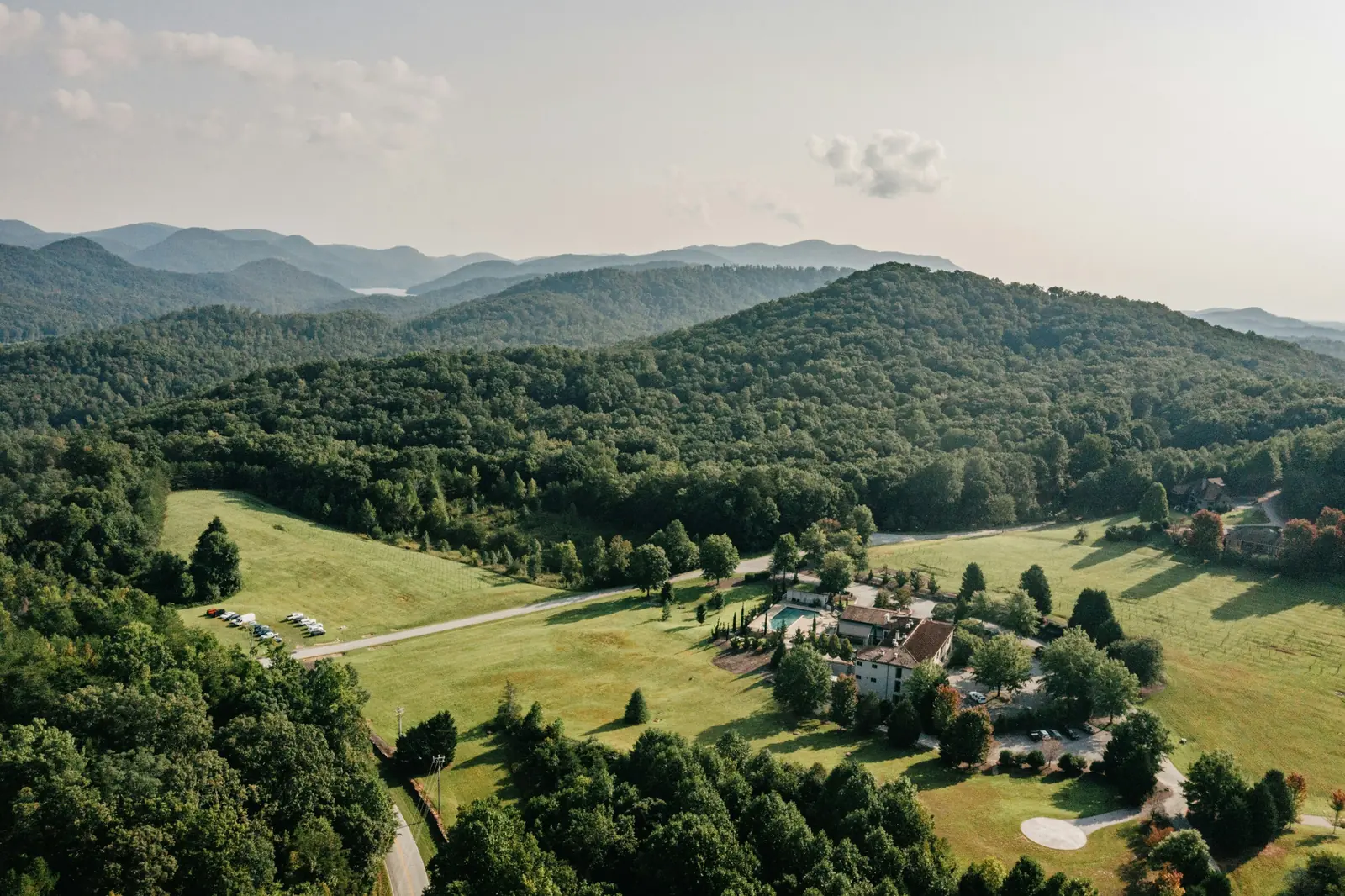 Aerial view of green foothills and pasture near Travelers Rest, South Carolina with the Blue Ridge Mountains beyond